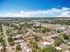 Aerial view showcases a lakefront neighborhood with streets, trees, houses and nearby commercial area at 320 S Seminole Ave, Lake Alfred, FL 33850