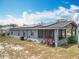 Exterior view of a home with solar panels, screened porch, and a grassy backyard with room to enjoy at 320 S Seminole Ave, Lake Alfred, FL 33850