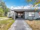 Home featuring a front entrance with a covered porch, driveway, and well-maintained landscaping at 320 S Seminole Ave, Lake Alfred, FL 33850