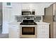 Bright kitchen with stainless steel appliances, white cabinets, and stylish backsplash at 320 S Seminole Ave, Lake Alfred, FL 33850