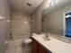 Bathroom with beige tiled walls, vanity, toilet, and shower-tub combo at 340 Cimarron Ct, Poinciana, FL 34759