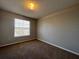 An empty room with carpet, a window with blinds, and electrical outlets on the light grey wall at 340 Cimarron Ct, Poinciana, FL 34759