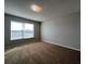A spacious and airy bedroom with large windows, gray walls, neutral carpet and a ceiling light fixture at 340 Cimarron Ct, Poinciana, FL 34759