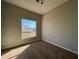 An empty room with carpet, a window with blinds, and electrical outlets on the light grey wall at 340 Cimarron Ct, Poinciana, FL 34759