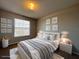 Comfortable bedroom with a bed, two nightstands with lamps and cartoon art decorations on the wall at 340 Cimarron Ct, Poinciana, FL 34759