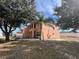 Two-story peach home with a well-maintained lawn surrounded by beautiful trees at 340 Cimarron Ct, Poinciana, FL 34759