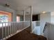 Hallway featuring brown carpet, white railing, and natural light from a window at 340 Cimarron Ct, Poinciana, FL 34759