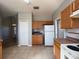 Cozy kitchen with light wood cabinets, appliances, tile backsplash, and easy access to the adjacent living space at 340 Cimarron Ct, Poinciana, FL 34759