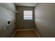 Laundry room with window, wire shelving, and available hookups for laundry appliances at 340 Cimarron Ct, Poinciana, FL 34759