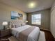 Comfortable primary bedroom with tufted headboard, plush bedding, and decorative ocean artwork at 340 Cimarron Ct, Poinciana, FL 34759
