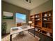 Well-lit home office with a large window, modern desk, and stylish built-in shelving at 340 Cimarron Ct, Poinciana, FL 34759