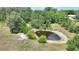 Scenic view of a serene pond surrounded by lush trees and a well-kept house, creating a tranquil landscape at 3440 La Salle Ave, St Cloud, FL 34772