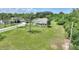 White home with a spacious lawn featuring mature trees and lush greenery from an aerial perspective at 3440 La Salle Ave, St Cloud, FL 34772