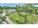 Aerial view of a white, single-story home featuring a spacious, well-maintained lawn with mature trees at 3440 La Salle Ave, St Cloud, FL 34772