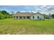 A white home with a green backyard and a covered patio at 3440 La Salle Ave, St Cloud, FL 34772