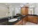 Bathroom with double sink vanity, granite countertop, wood cabinets, and large mirror at 3440 La Salle Ave, St Cloud, FL 34772