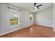 Minimalist bedroom with natural light and a ceiling fan. Features wood-look floors and neutral walls at 3440 La Salle Ave, St Cloud, FL 34772