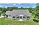 An angled view of the home showing the front porch, well-kept lawn, and lush greenery surrounding the property at 3440 La Salle Ave, St Cloud, FL 34772