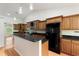 Spacious kitchen with wooden cabinets, modern appliances, granite countertops, and an island with a sink at 3440 La Salle Ave, St Cloud, FL 34772