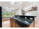 Well-lit kitchen with granite countertops, wood cabinets, stainless steel sink, and a view of the green outdoors at 3440 La Salle Ave, St Cloud, FL 34772