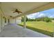 Covered patio with ceiling fans overlooking spacious yard and greenery creates an inviting outdoor living space at 3440 La Salle Ave, St Cloud, FL 34772