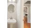 Clean and bright powder room features pedestal sink, oval mirror, and view to hallway at 3440 La Salle Ave, St Cloud, FL 34772