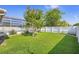 A spacious backyard boasts green grass, a privacy fence, and access to a screened-in pool at 454 Eagle Dr, Kissimmee, FL 34759