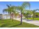 Charming single-story home featuring a well-manicured lawn, a two-car garage, and decorative palm trees at 454 Eagle Dr, Kissimmee, FL 34759