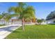Charming single-story home featuring a well-manicured lawn, a two-car garage, and decorative palm trees at 454 Eagle Dr, Kissimmee, FL 34759