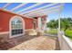 Covered outdoor patio with brick flooring, decorative stone supports, and a white picket fence at 454 Eagle Dr, Kissimmee, FL 34759