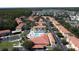 Aerial view of the neighborhood featuring the pool, lush landscaping, and a pond in the background at 4707 Pershoie Ln, Kissimmee, FL 34746
