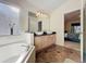 Bright bathroom with double sinks, tub, tile floor and doorway leading into the bedroom at 4707 Pershoie Ln, Kissimmee, FL 34746