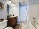 Standard bathroom with a tile floor, single sink vanity, large mirror, shower-tub combination and linen closet at 4707 Pershoie Ln, Kissimmee, FL 34746