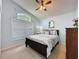 Light-filled bedroom features a queen bed, ceiling fan, window and light blue walls at 4707 Pershoie Ln, Kissimmee, FL 34746