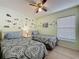 bedroom featuring 2 twin beds, a ceiling fan, and construction vehicle themed wall decorations at 4707 Pershoie Ln, Kissimmee, FL 34746