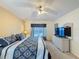 Comfortable bedroom with a queen-sized bed, ceiling fan, and a large wicker dresser with a TV at 4707 Pershoie Ln, Kissimmee, FL 34746