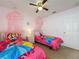bedroom featuring 2 twin beds, a ceiling fan, a window, and pink canopies above each bed at 4707 Pershoie Ln, Kissimmee, FL 34746