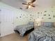 bedroom featuring 2 twin beds, a ceiling fan, and construction vehicle themed wall decorations at 4707 Pershoie Ln, Kissimmee, FL 34746
