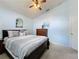Bedroom with queen bed, ceiling fan, dresser, and decorative mirror at 4707 Pershoie Ln, Kissimmee, FL 34746