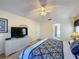 Bedroom view of a queen-size bed, dresser with TV, and an open door to the Primary bath at 4707 Pershoie Ln, Kissimmee, FL 34746