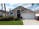 Charming single-Gathering home with a well-maintained lawn, blue door, and two-car garage at 4707 Pershoie Ln, Kissimmee, FL 34746