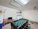 Bright game room features a foosball table, a tv on a small table and a washer and dryer setup at 4707 Pershoie Ln, Kissimmee, FL 34746