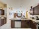 View of a kitchen island featuring granite countertops, stainless steel appliances, and dark cabinets at 4707 Pershoie Ln, Kissimmee, FL 34746