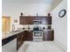 Kitchen with granite counters, stainless appliances, and dark wood cabinets at 4707 Pershoie Ln, Kissimmee, FL 34746
