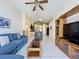 Inviting living room with tile flooring, ceiling fan, and comfortable blue sofa at 4707 Pershoie Ln, Kissimmee, FL 34746