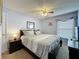 Spacious main bedroom featuring a ceiling fan, bedside table and a window dressed with blinds and drapes at 4707 Pershoie Ln, Kissimmee, FL 34746