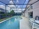 Beautiful screened-in pool with lounge chairs and an outdoor dining area at 4707 Pershoie Ln, Kissimmee, FL 34746