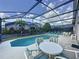 Inviting screened-in pool area with lounge chairs and outdoor dining setup on a sunny day at 4707 Pershoie Ln, Kissimmee, FL 34746