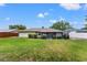 Well-manicured backyard with a lush lawn, mature landscaping, and a screened-in patio at 4824 Reginald Rd, Orlando, FL 32829