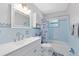 Well-lit bathroom featuring blue tile, a white vanity, and a combination tub and shower at 512 Maryland Ave, St Cloud, FL 34769
